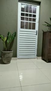 a white door with a potted plant in a room at Casa Frida 1 in Natal