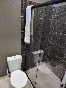 a bathroom with a toilet and a glass shower at Casa Frida 1 in Natal