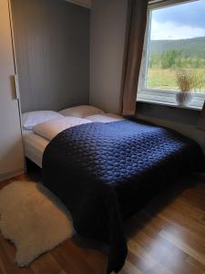 Schlafzimmer mit einem Bett vor einem Fenster in der Unterkunft Idyllisk hus med sauna og jacuzzi, Lyngen in Nord-Lenangen