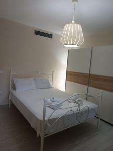 a bedroom with a white bed with a light at Peramos View Luxury Maisonette in Nea Peramos