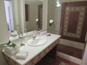 ein Badezimmer mit einem Waschbecken und einem großen Spiegel in der Unterkunft Kerameion in Athen