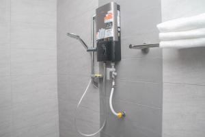 a shower in a bathroom with aitizer at THE SPACE SRI AMAN in Simanggang