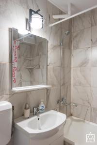 ein Badezimmer mit einem Waschbecken, einem WC und einem Spiegel in der Unterkunft Ana Apart in Gheorgheni