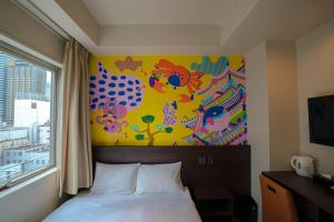 大阪市にあるLub d Osaka Honmachiのベッドルーム1室(ベッド1台付)が備わります。壁には絵画が飾られています。