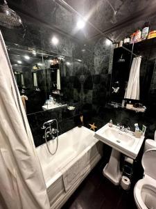 a black and white bathroom with a tub and a sink at Perfect West End Launchpad in London