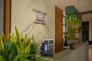 un vestíbulo con una señal para un complejo hawaiano en Courtyard Holiday Resort, en Saint Yeorgios 100 fotos más
