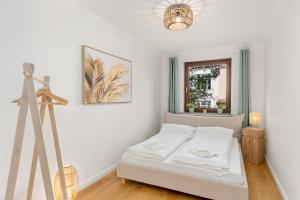 a white bedroom with a bed and a tripod at Modern Oak-Apartment für bis zu 6 Personen in Bremen