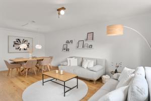 a living room with a couch and a table at Modern Oak-Apartment für bis zu 6 Personen in Bremen
