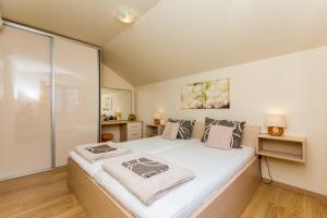 a bedroom with a large bed with white sheets at Apartments Šiljug in Cavtat