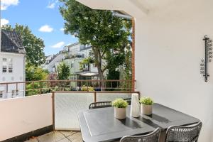 patio con mesa y sillas en el balcón en Modern Oak-Apartment für bis zu 6 Personen, en Bremen