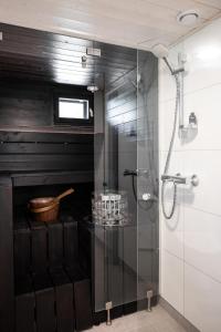 y baño con ducha acristalada y paredes negras. en Himoskuutio 3, erillistalo, ulkoporeallas en Jämsä
