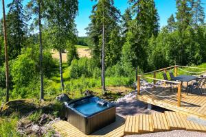 a hot tub on a wooden deck with a patio at Himoskuutio 3 in Jämsä