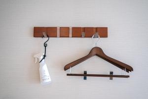 a wooden hanger on a wall with a soap bottle at Lub d Osaka Honmachi in Osaka