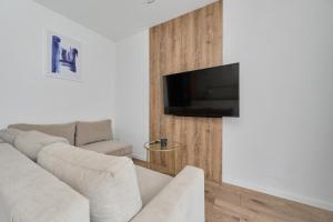A television and/or entertainment centre at Stylish Apartment in Prestige Riverside Location Księcia Witolda by Renters