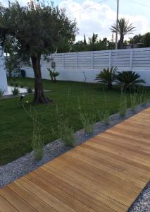 a wooden walkway with a tree in a yard at Casa Solà in Menfi