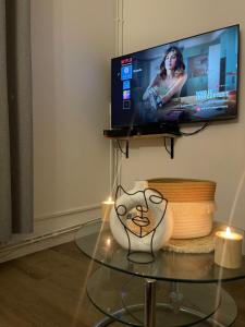 a living room with a tv and a glass table at 2 pièces Metro 13 Porte de Paris - Stade de France in Saint-Denis