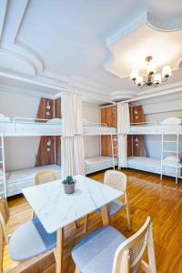 Habitación con mesa, sillas y literas. en White hostel Mongolia, en Ulán Bator