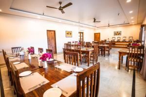 a dining room with wooden tables and chairs at RajBagh by Aaryam in Sawāi Mādhopur
