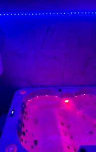 a pink bathtub with a red light in a room at Main de Bouddha et nonchalance in Arras