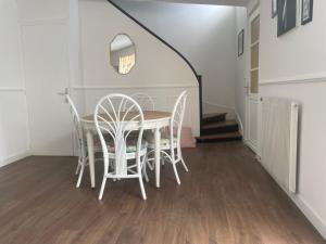 a dining room with a table and chairs at Main de Bouddha et nonchalance in Arras