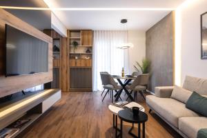 ein Wohnzimmer mit einem Sofa und einem TV in der Unterkunft The five star apartment in Thessaloniki