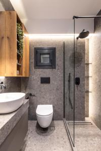 ein Bad mit einem WC, einem Waschbecken und einer Dusche in der Unterkunft The five star apartment in Thessaloniki