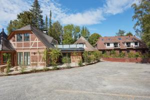 une grande maison avec une allée en face de celle-ci dans l'établissement Boutique Hotel Waldwiese, à Hohwacht