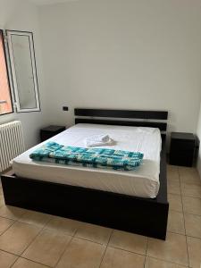 una cama con marco negro y sábanas blancas en Casa di Giusi, en Bolonia