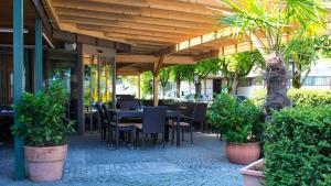 eine Terrasse mit einem Tisch, Stühlen und Pflanzen in der Unterkunft Hotel Badhof in Altstätten