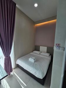 a small bedroom with a bed and a window at TT99 COZY STAY in Miri