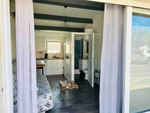 a room with a bed and a table and a kitchen at Studio carnon climatisé à 5min à pied de la plage in Mauguio