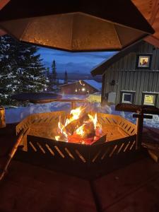 eine Feuerstelle auf einer Terrasse vor einem Haus in der Unterkunft Ottsjö-Åre Lodge in Ottsjö