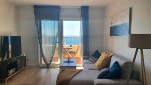 uma sala de estar com um sofá e vista para o oceano em PALM TOWER APARTMENT em Roquetas de Mar