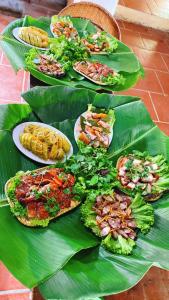 una tavola con piatti di cibo su una foglia di banana di Boong Home - Pác Bó, Cao Bằng 