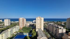 uma vista para uma cidade com edifícios altos e o oceano em PALM TOWER APARTMENT em Roquetas de Mar