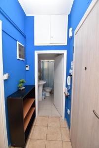 a bathroom with a blue wall and a toilet at Prive Apartment Thessaloniki-Easy Parking in Thessaloniki
