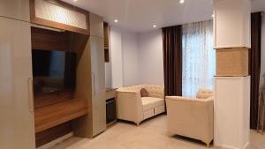 sala de estar con 2 sillas y TV de pantalla plana en The Grand Hotel en Āīzawl