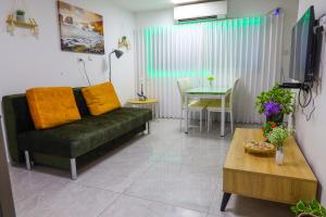 - un salon avec un canapé vert et une table dans l'établissement דירת יהלום חדשה ומודרנית 5 דקות נסיעה מהים, à Ashkelon