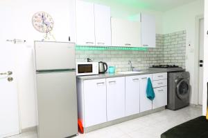 een keuken met een koelkast en een wasmachine bij דירת יהלום חדשה ומודרנית 5 דקות נסיעה מהים in Ashkelon
