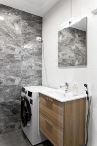 ein Badezimmer mit Waschbecken und Waschmaschine in der Unterkunft Forenom Serviced Apartments Pori Antinkatu in Pori + 22 Fotos