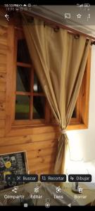 ein Fenster in einem Zimmer mit einem Vorhang in der Unterkunft La Maison des Fous in Papudo