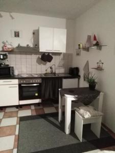 a kitchen with a stove and a table in it at Studiowohnung, Neu renoviert, zentrale Lage in Saarlouis