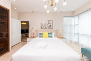 Charming Brand New 2BR close to the Beach في دبي: غرفة نوم بيضاء كبيرة مع سرير أبيض كبير
