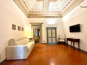 a living room with a white couch and a television at Raffaello - M&M Holiday House in Perugia +37 photos