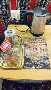 a table with a tray of food and a kettle at private farmhouse Tent Room in Al Rahba