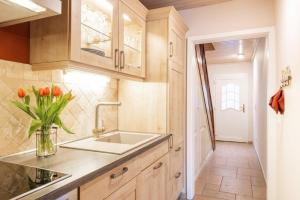 a kitchen with a sink and a vase of flowers at Kamin-Haus-Nr-3-mit-Sauna-in-Burg in Fehmarn