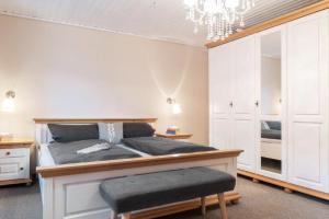 a bedroom with a bed and a chandelier at Kamin-Haus-Nr-3-mit-Sauna-in-Burg in Fehmarn