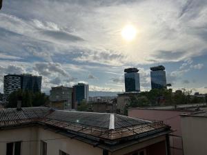 a view of a city with the sun in the sky at Moonlight Shadow Apartment in Sarajevo