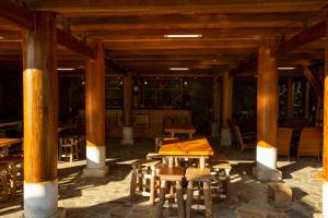 - un pavillon avec piliers en bois, tables et chaises dans l'établissement O'chau Homestay Sapa, à Lào Cai