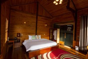 O'chau Homestay Sapa في لاو كاي: غرفة نوم بسرير كبير في غرفة خشبية